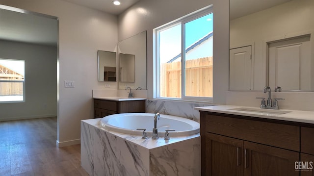 16903 Mairs Dr, Bakersfield, CA 93314 - full bathroom with two vanities, a garden tub, wood finished floors, and recessed lighting