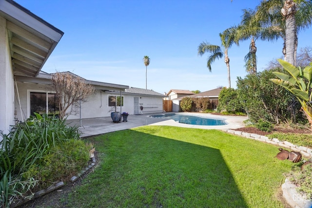 back of property featuring a fenced in pool, a yard, a patio, stucco siding, and fence