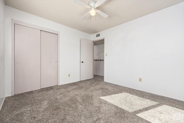 unfurnished bedroom featuring visible vents, a ceiling fan, a textured ceiling, carpet floors, and a closet