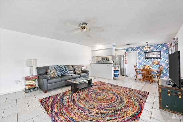 living room with light tile patterned floors, a textured ceiling, and a ceiling fan