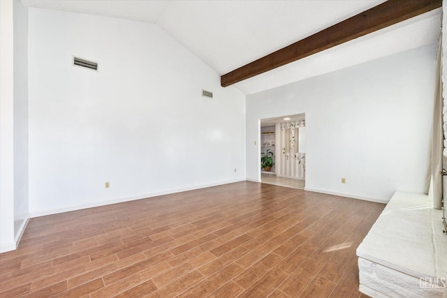 unfurnished living room with baseboards, visible vents, wood finished floors, and beamed ceiling