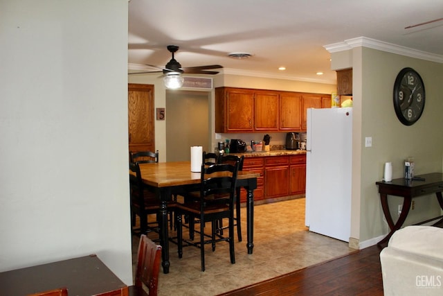 6813 Melones Ct, Bakersfield, CA 93309 - kitchen with crown molding, brown cabinets, light wood-style floors, ceiling fan, and freestanding refrigerator