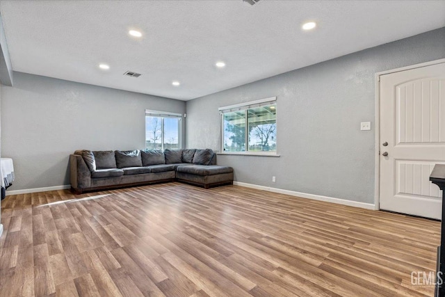 living room with light hardwood / wood-style flooring and a textured ceiling