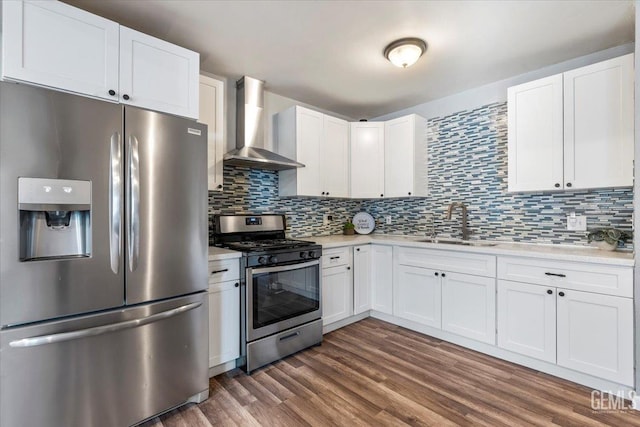 kitchen with sink, appliances with stainless steel finishes, dark hardwood / wood-style floors, white cabinets, and wall chimney exhaust hood