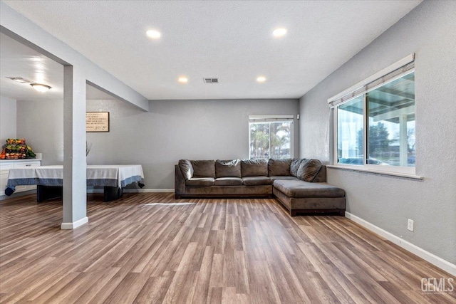 unfurnished living room with a textured ceiling and light wood-type flooring