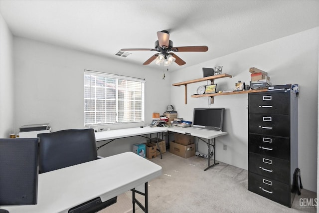 carpeted home office featuring ceiling fan