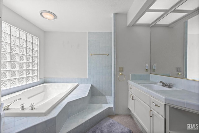 bathroom featuring tiled bath and vanity