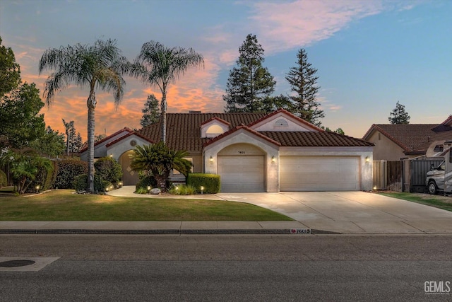 mediterranean / spanish home featuring a lawn and a garage