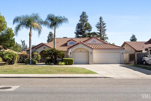 mediterranean / spanish house featuring a garage and a front lawn