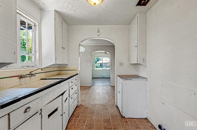 120 Pacific St, Bakersfield, CA 93305 - kitchen with backsplash, arched walkways, and white cabinets