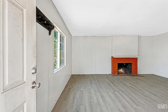120 Pacific St, Bakersfield, CA 93305 - unfurnished living room featuring wood finished floors and a brick fireplace