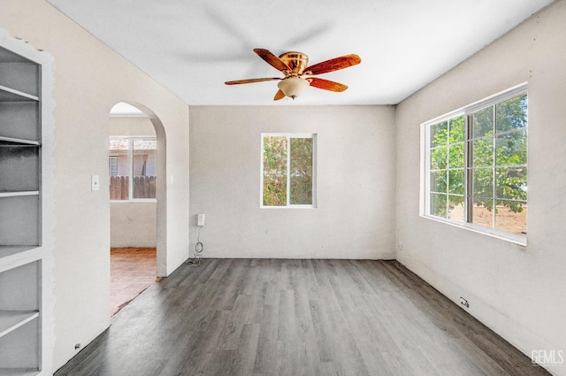 120 Pacific St, Bakersfield, CA 93305 - empty room featuring wood finished floors, plenty of natural light, arched walkways, and a ceiling fan