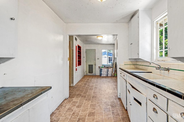 120 Pacific St, Bakersfield, CA 93305 - kitchen with white cabinets and decorative backsplash