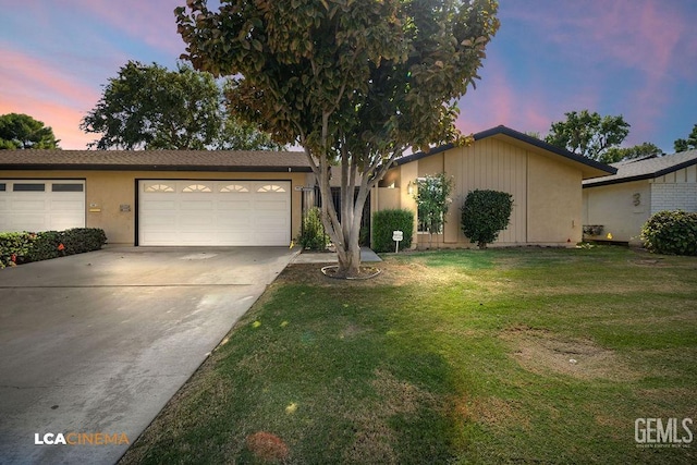 ranch-style house with concrete driveway, a front lawn, stucco siding, and an attached garage