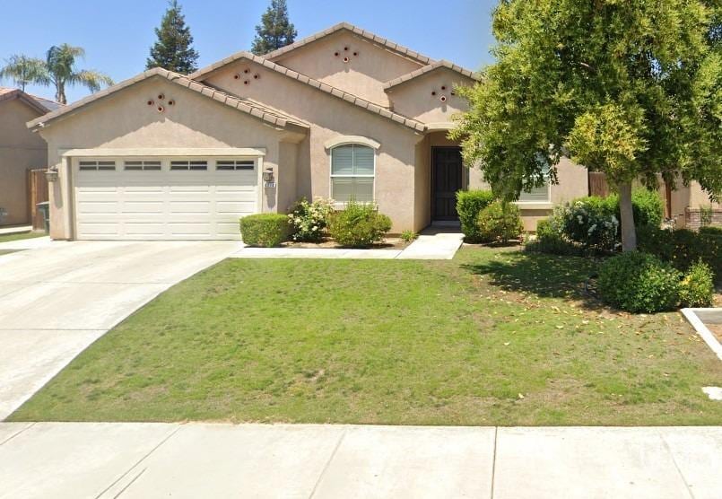 6210 Baguette Ave, Bakersfield, CA 93313 - mediterranean / spanish house featuring an attached garage, stucco siding, a front lawn, driveway, and a tiled roof