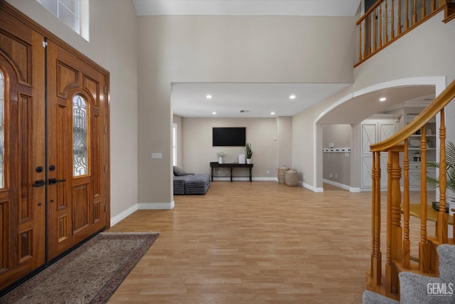214 Driver Rd, Bakersfield, CA 93314 - entryway featuring arched walkways, stairway, a high ceiling, light wood-style floors, and baseboards