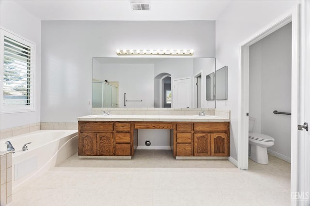 bathroom featuring double vanity, a stall shower, toilet, visible vents, and a garden tub
