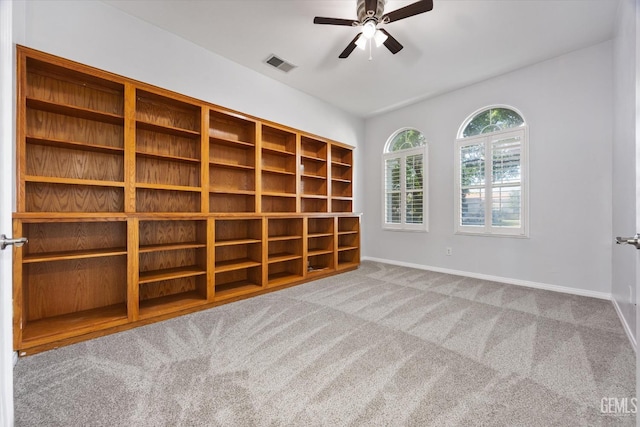 carpeted empty room with baseboards, a ceiling fan, and visible vents