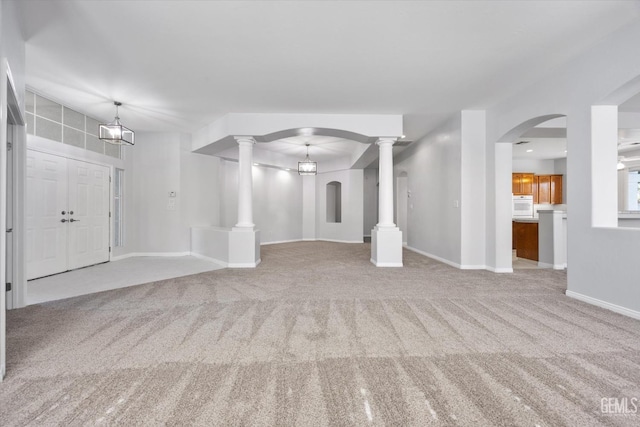 unfurnished living room featuring baseboards and carpet floors
