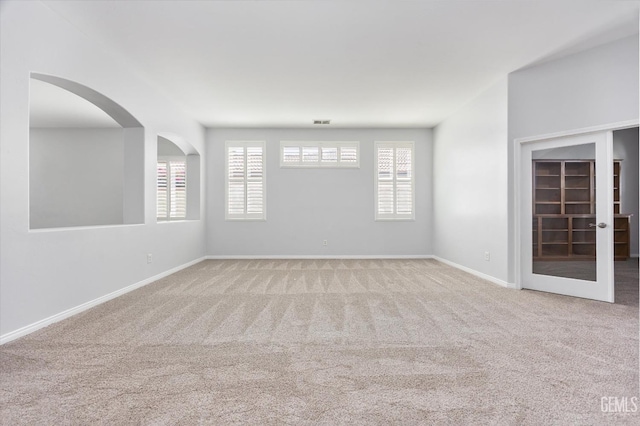 carpeted empty room featuring visible vents and baseboards