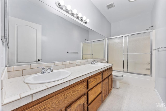 bathroom featuring toilet, double vanity, a sink, and visible vents