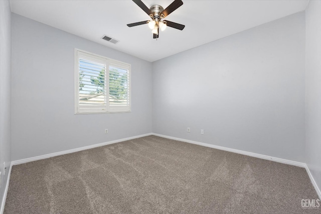 carpeted empty room with baseboards, a ceiling fan, and visible vents