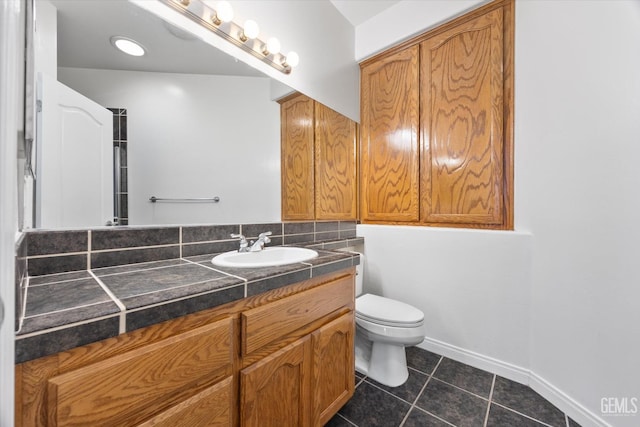 bathroom with tile patterned floors, toilet, vanity, and baseboards