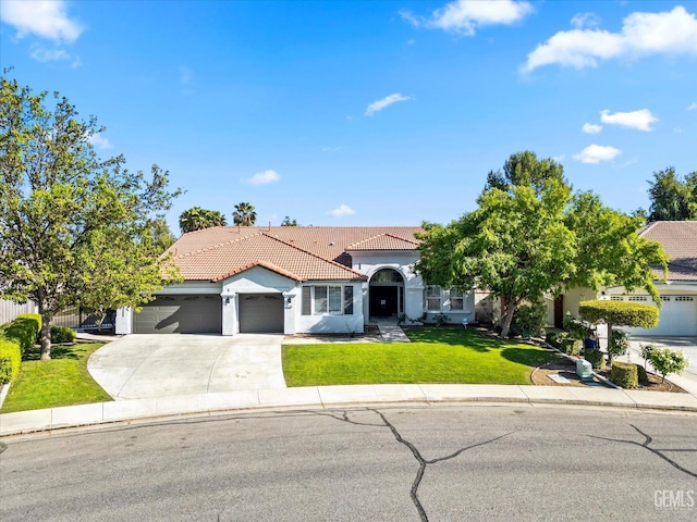 mediterranean / spanish home with concrete driveway, stucco siding, a front lawn, a garage, and a tiled roof
