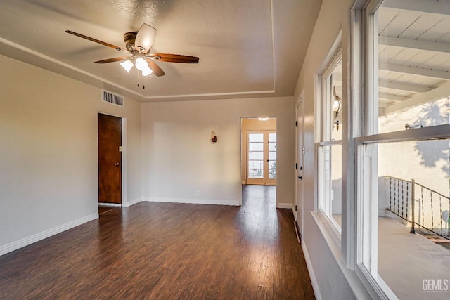 unfurnished room with dark wood-type flooring, ceiling fan, and beamed ceiling