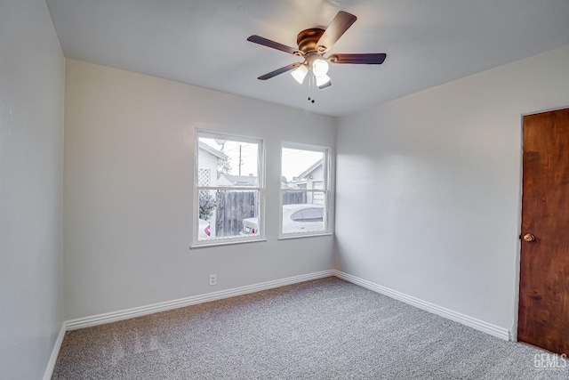 empty room featuring ceiling fan and carpet