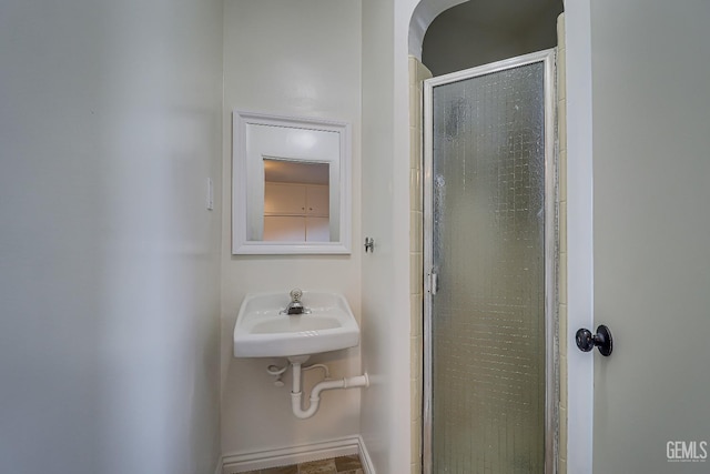 bathroom featuring sink and a shower with door