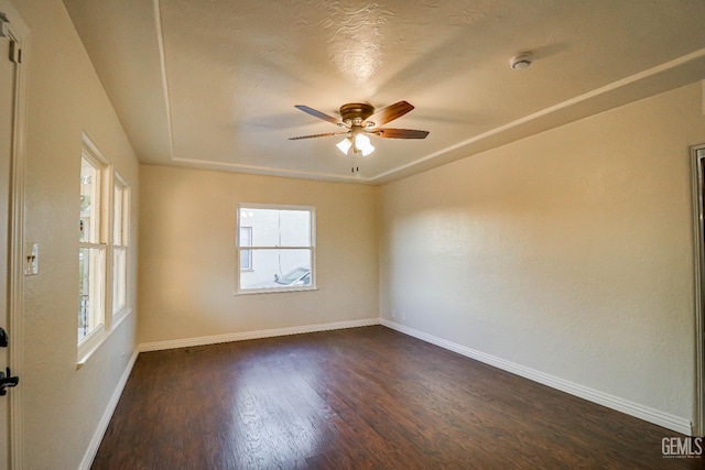 empty room with dark hardwood / wood-style floors and ceiling fan