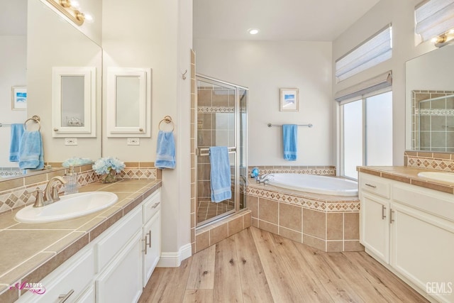 bathroom with tasteful backsplash, vanity, independent shower and bath, and hardwood / wood-style floors