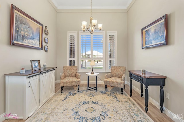 living area featuring a notable chandelier, crown molding, and light hardwood / wood-style flooring