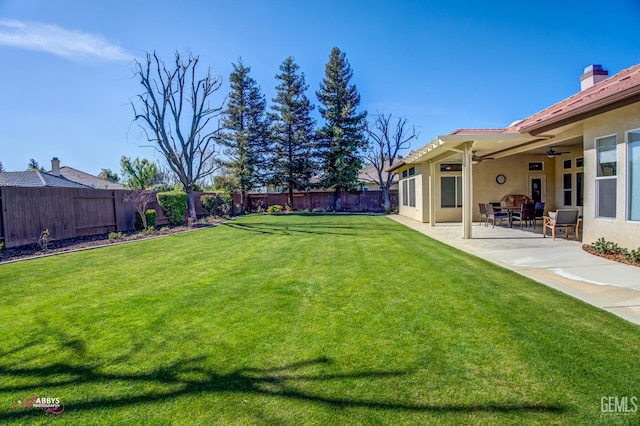 view of yard featuring ceiling fan and a patio