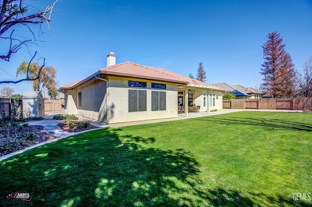 rear view of house with a patio and a yard