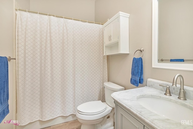 bathroom featuring vanity, walk in shower, and toilet