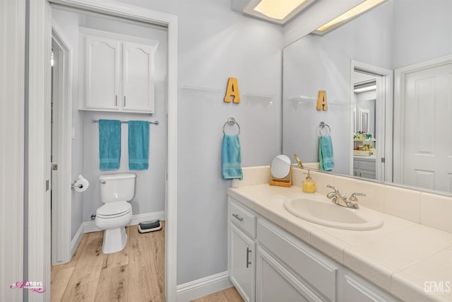 bathroom with vanity, wood-type flooring, and toilet