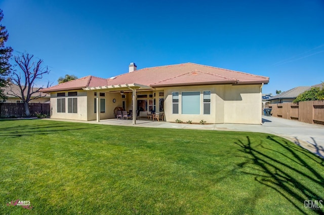 back of house with a yard and a patio