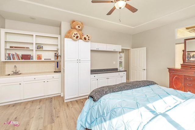 bedroom with ceiling fan, light hardwood / wood-style floors, and sink