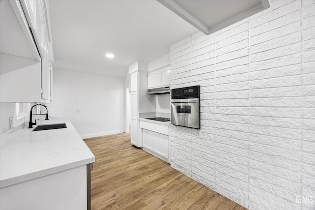 kitchen featuring sink, white cabinetry, black electric stovetop, oven, and light hardwood / wood-style floors