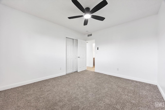 unfurnished bedroom with carpet, ceiling fan, and a closet