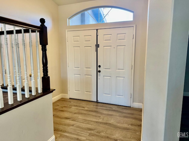 foyer entrance featuring light wood-type flooring and baseboards