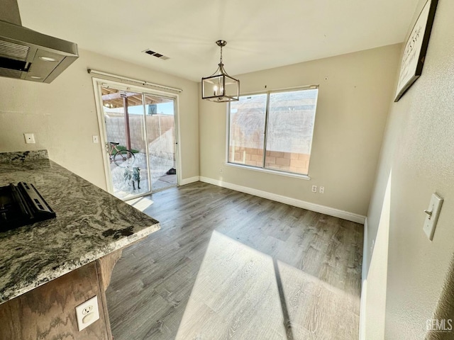 dining space featuring dark wood-style floors, a chandelier, visible vents, and baseboards