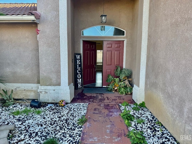 property entrance with a tiled roof and stucco siding