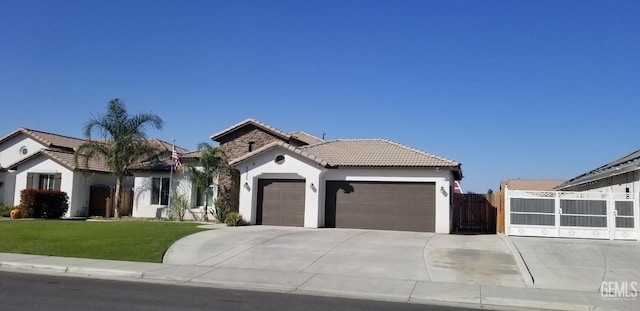 mediterranean / spanish house featuring a garage and a front lawn