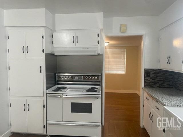 kitchen with white electric stove, white cabinetry, baseboards, under cabinet range hood, and dark wood-type flooring