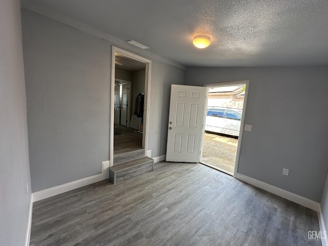 spare room featuring hardwood / wood-style floors and a textured ceiling