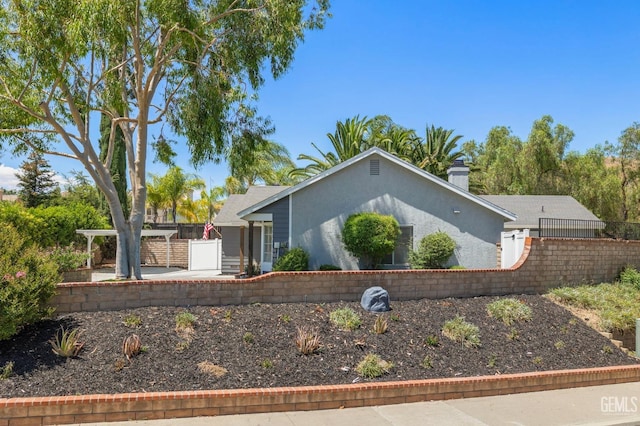 view of front of home featuring a patio area, fence, and stucco siding