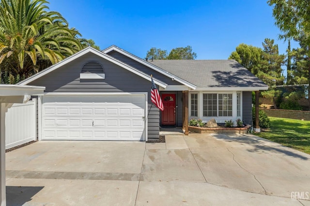 ranch-style house with driveway, an attached garage, and fence